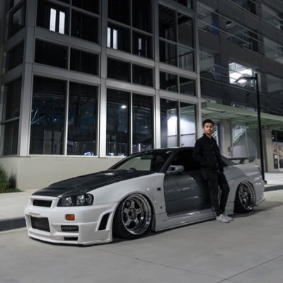 Randy Truong posing in front of a car
