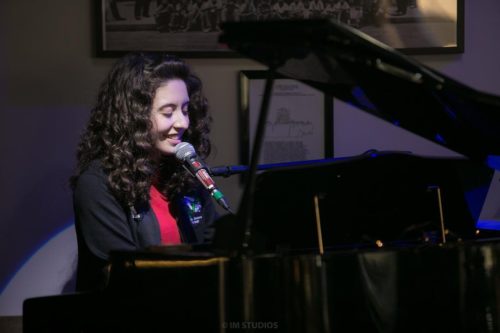 Olivia Presti playing piano and singing